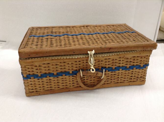 Cane sewing basket with blue stripe.