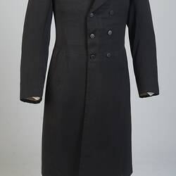 Gentleman's black cotton frock coat, six-button, double-breasted with peaked lapels.