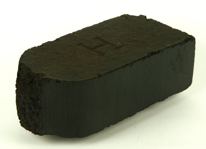 Rectangular black briquette with broken end.