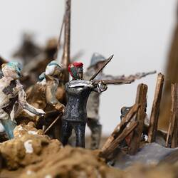 Detail of figurines representing miners engaged in fighting with guns and weapons.