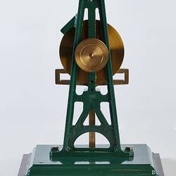 Metal model with green painted frame with metal circular shape and horizontal piece.
