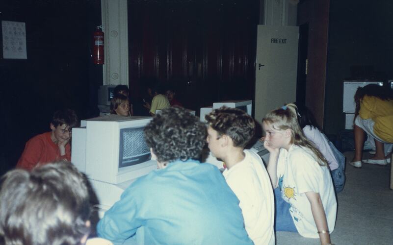 Students sitting on the floor working on computers.