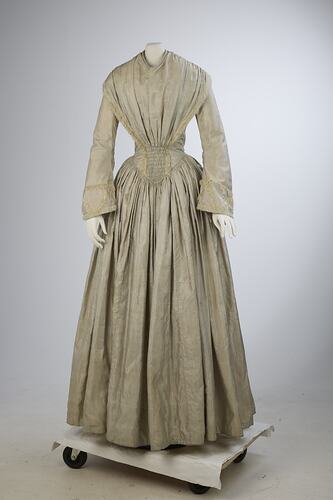 Pale grey striped silk dress with long sleeves and long skirt.