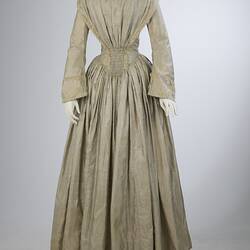 Pale grey striped silk dress with long sleeves and long skirt.