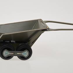 Plastic grey toy trailer with two wheels. Right profile view.