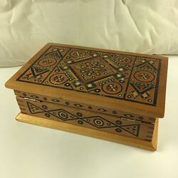 Timber inlay jewellery box. Geometric patterns in dark and light light brown, blue, yellow, white and red.