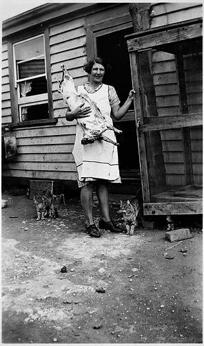 [Jessie Marsh stowing a side of lamb in the open air, fly proof meat safe, Werrimull South, Mallee, 1936.]