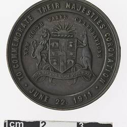 Round medal with coat of arms and text surrounding