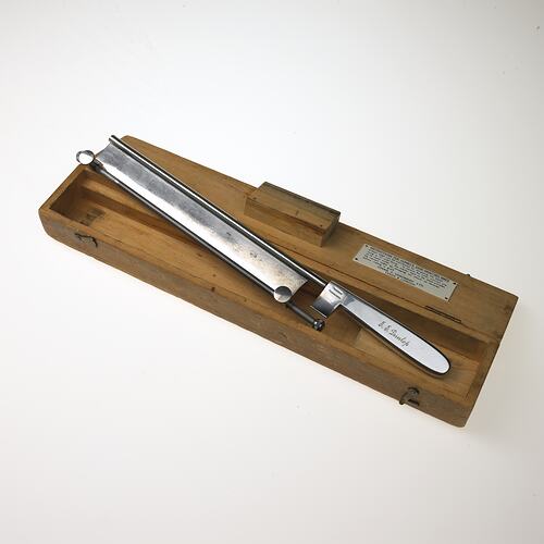 Knife used in surgery on wooden block.