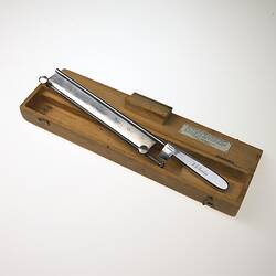 Knife used in surgery on wooden block.