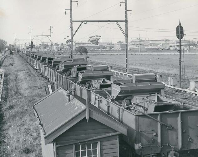 Header harvesters loaded onto rail wagons in siding.