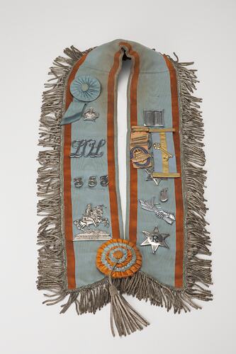 Pale blue, tassle-trimmed collar, lined with badges.