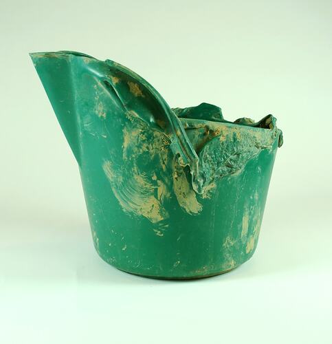 Partially melted green plastic bucket