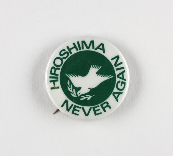 Badge - green background, white dove, words 'Hiroshima Never Again'