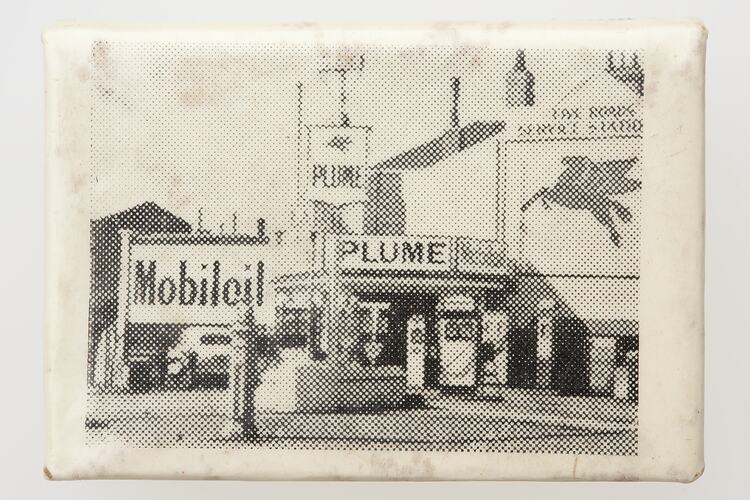 White matchbox cover with black printed image of service station.