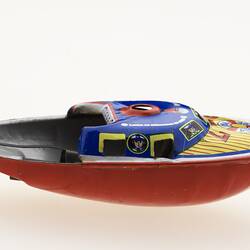 Brightly coloured little metal speedboat toy.