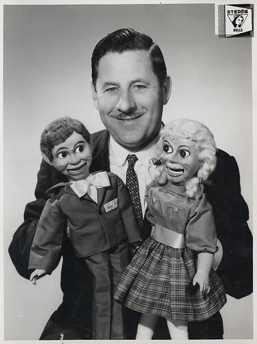 Man holding two ventriloquist dolls.