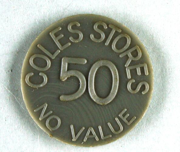 Grey plastic circular disc, printed on each side; 'COLES STORES 50 NO VALUE'.