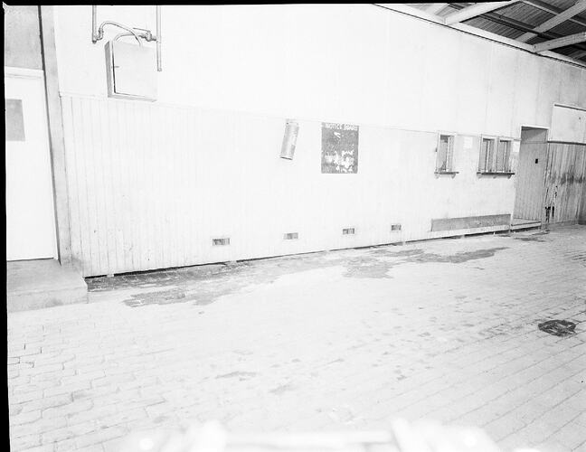 Monochrome photograph two men laying flooring.