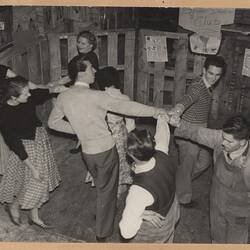 Group of 8 people dancing on warehouse floor.
