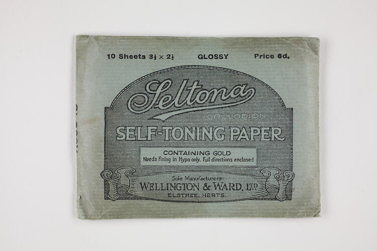 Blue-green paper packet with black text.