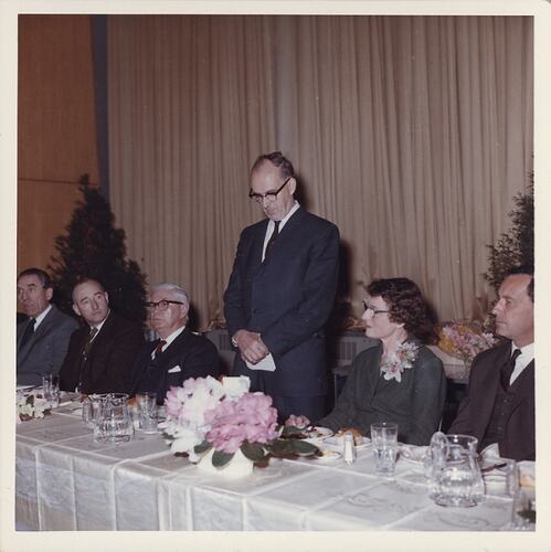 Man speaking at formal dinner.
