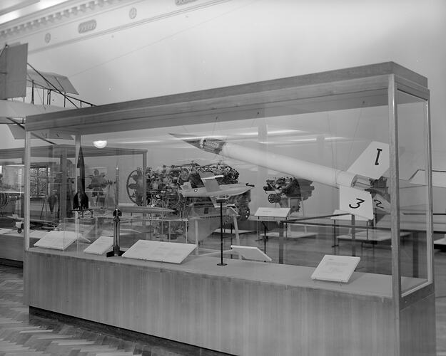 Museum interior with display case of model rockets and other space technology.