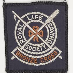 Blue square cloth badge with white and orange logo of a life buoy (ring) and crossed boat hook and oar.