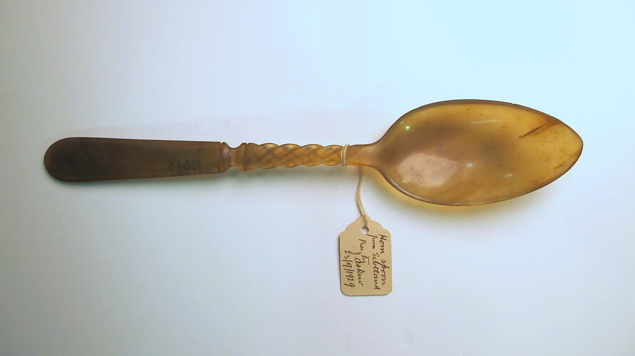 Horn spoon with paper label viewed from above.