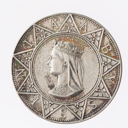 Round silver medal with Queen Victoria facing left with veil. Around her is a nine-pointed star with a letter