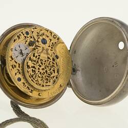 Pocket watch in case. Open to show decorative mechanism and engraving.