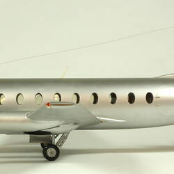 Silver model aeroplane with two propellers on each wing. Profile.