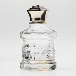Glass carousel shaped perfume bottle, gold plastic lid. Carousel has horses, swans.