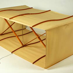 Box kite with two square sections made of cream fabric with wood and metal frame. Angle view.