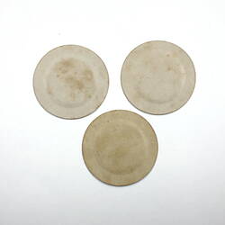 Three round paper plates, underside.