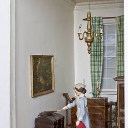 Doll's house interior room. Furnished and featuring costumed figure.