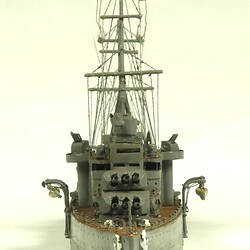 Naval ship with two masts, front view.