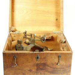 Wooden box open with instrument inside.