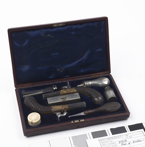 Pocket pistols in wooden case with accessories.