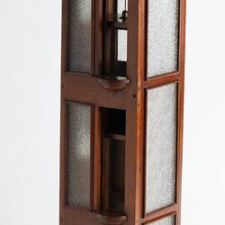 Passenger lift model. Wooden shaft has opaque glass windows and 3 floors, each with a sliding door.