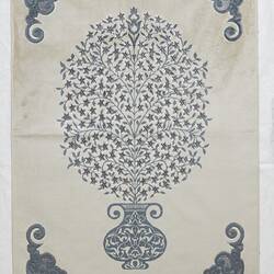 Cream prayer mat with blue print and embroidered central round motif and details in corners.