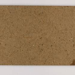 Plain back of a brown exhibition label.
