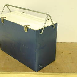 Blue cooler with white lid and metal handles.