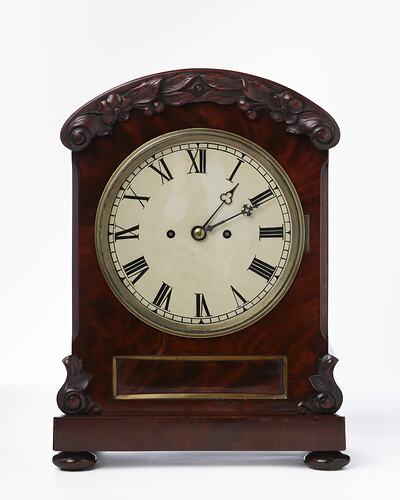 Mantel clock with white face and roman numerals. Mahogany case.