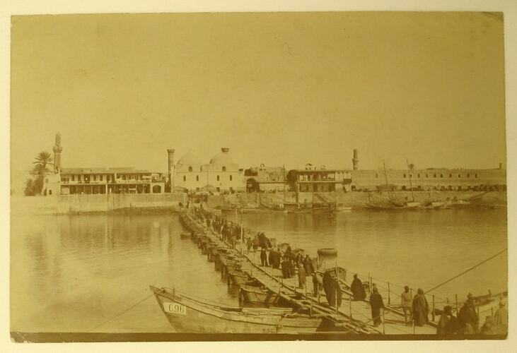 People walking across a pontoon bridge towards Baghdad.