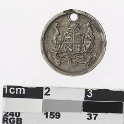 Round silver coloured medal with Australian coat of arms.