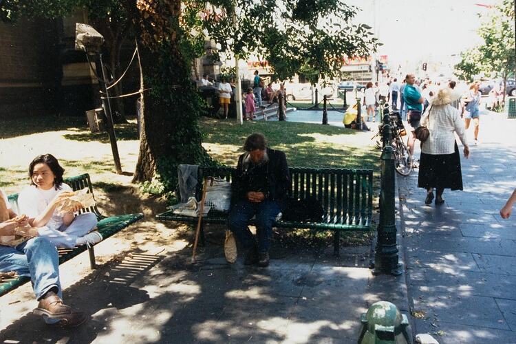 Digital Photograph - Homeless Man Resting on Seats by Saint Paul's Cathedral, Melbourne, 1990s