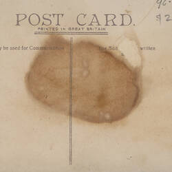Reverse side of a blank post card, with a large stain in the middle.