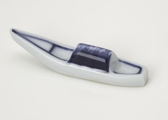 Boat shaped white ceramic with blue detail.