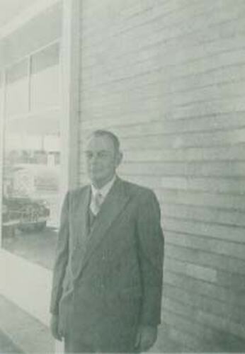 Portrait of a man standing outside a building.